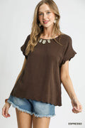 Woman wearing a brown top and denim shorts on a white background
