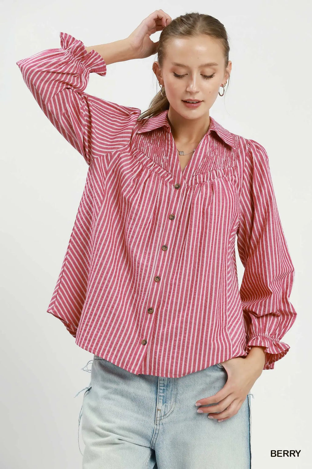 Woman wearing a red and white striped shirt with rolled-up sleeves on a white background