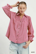 Woman wearing a red and white striped shirt with rolled-up sleeves on a white background