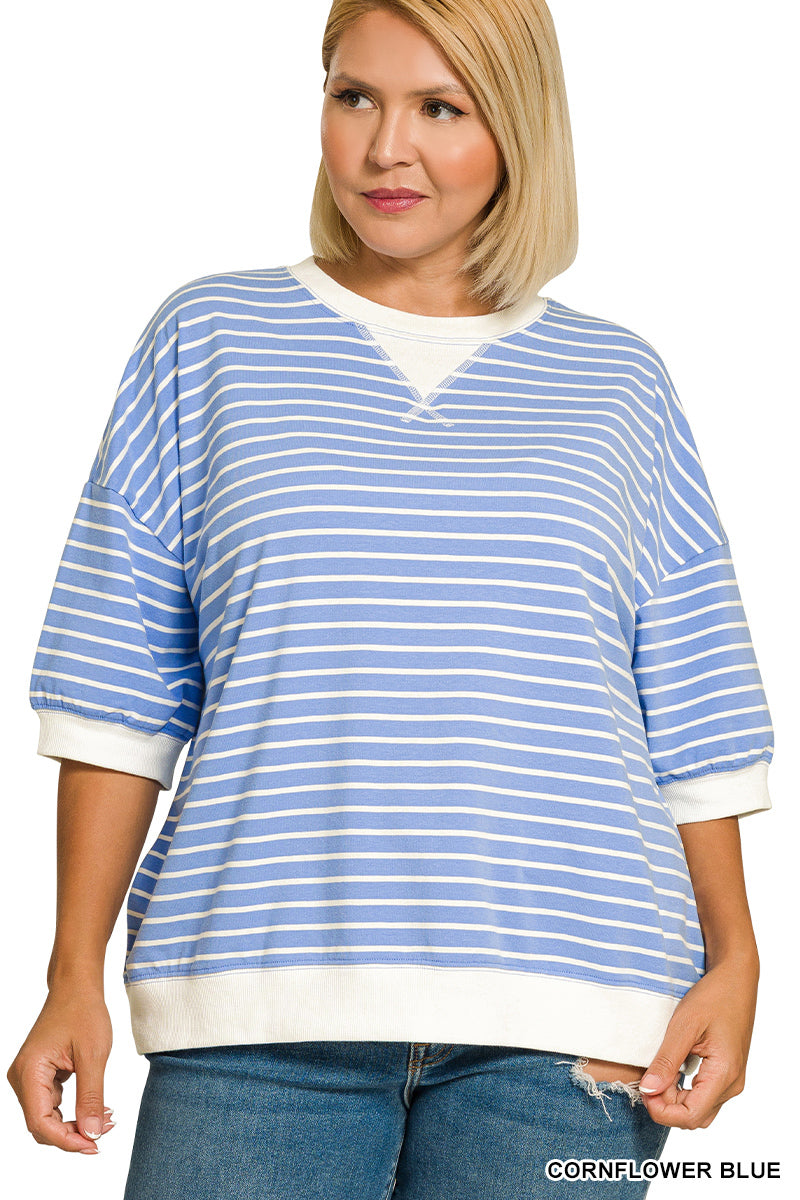 Woman wearing a blue and white striped sweater with a plain background