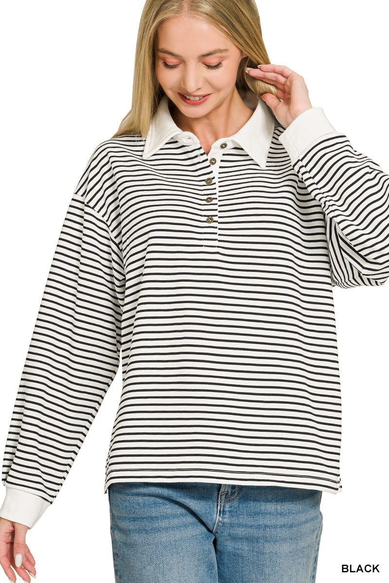 A woman wearing a black and white horizontally striped long-sleeve polo shirt with a white collar and button placket, paired with blue jeans, against a plain white background.