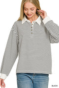 A woman wearing a black and white horizontally striped long-sleeve polo shirt with a white collar and button placket, paired with blue jeans, against a plain white background.