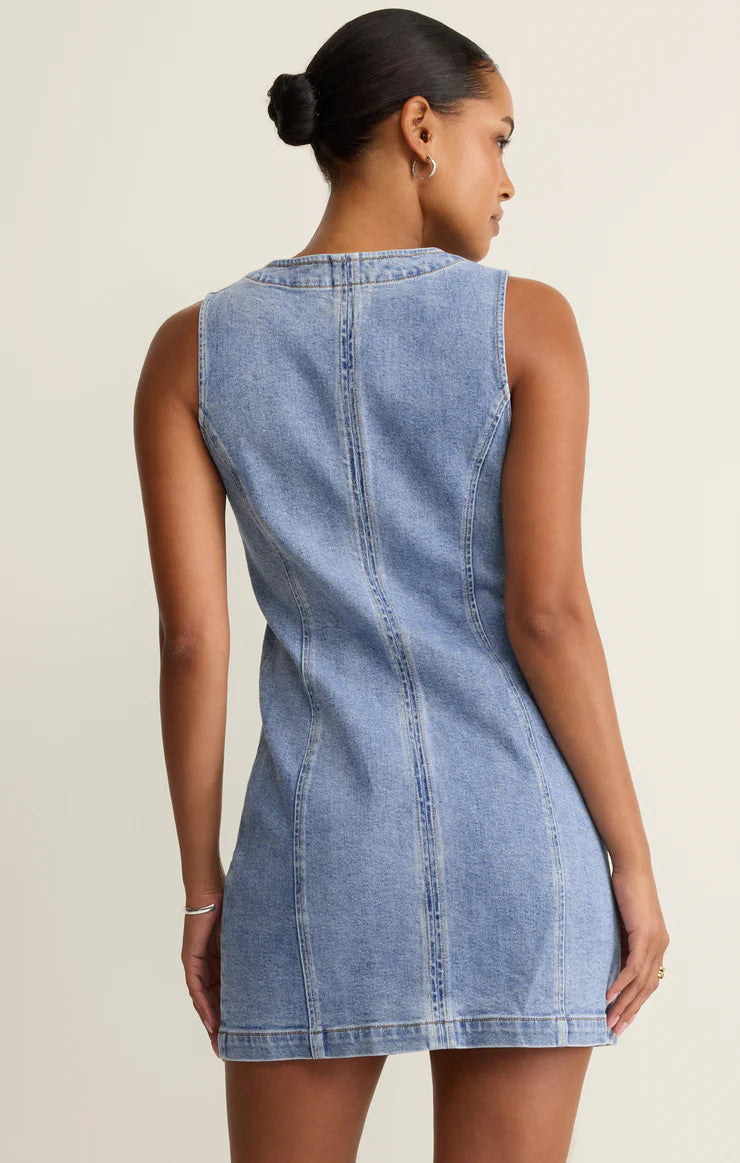 Woman wearing a denim dress against a plain background