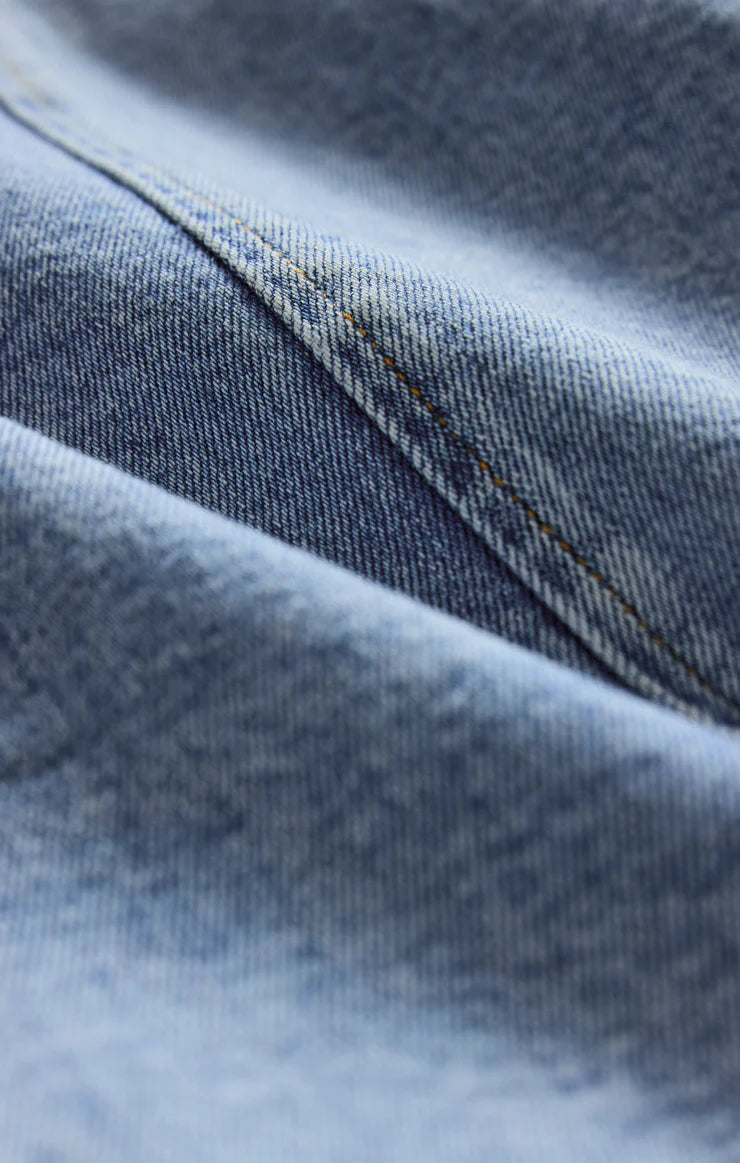 Close-up of blue denim fabric with visible stitching