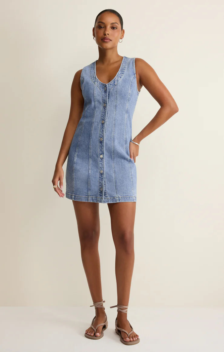 Woman wearing a denim dress against a plain background