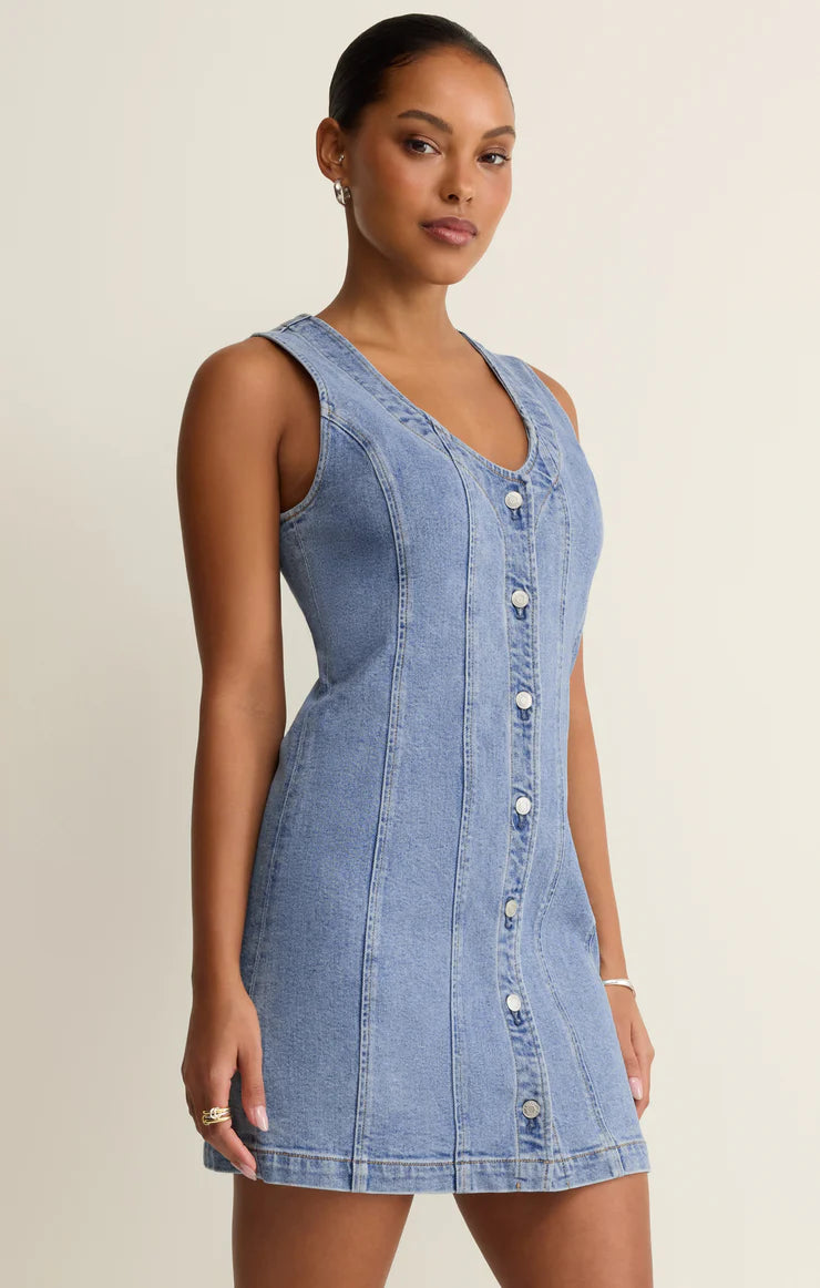 Woman wearing a denim dress with a beige background
