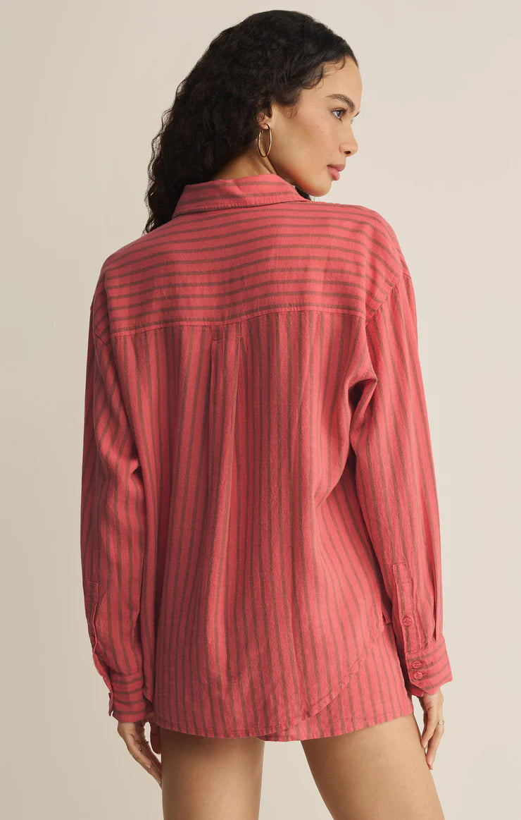 Woman wearing a red striped shirt against a beige background
