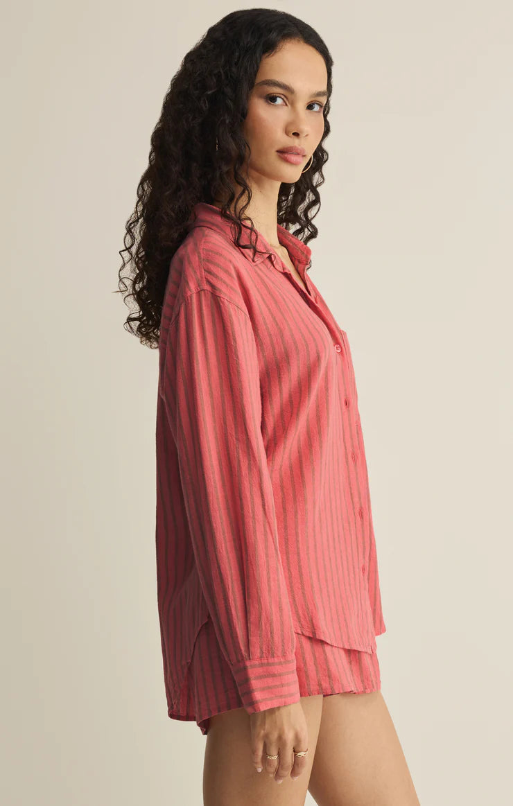 Woman wearing a pink pajama set against a beige background