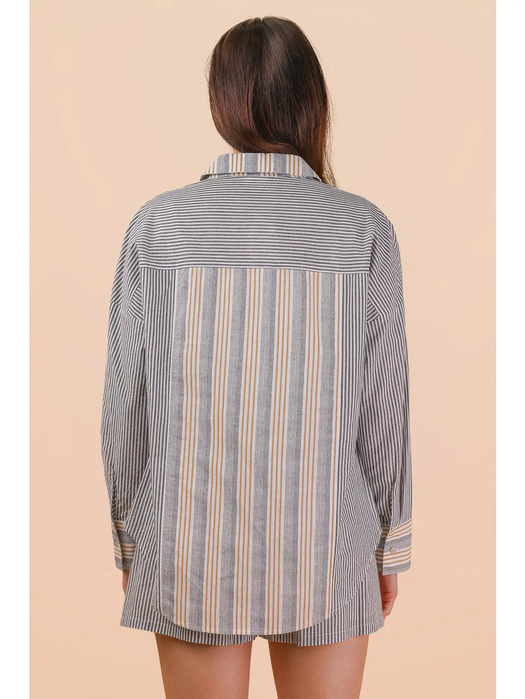 Person wearing a striped shirt with a beige background