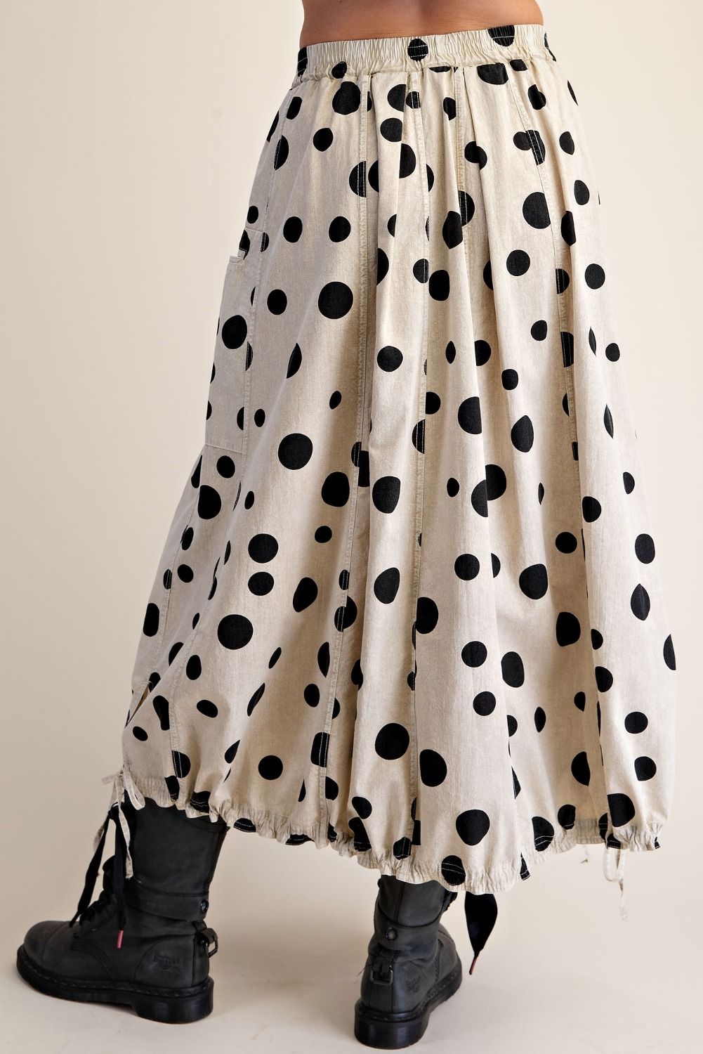 Polka dot skirt with black and white pattern worn by a person on a plain background