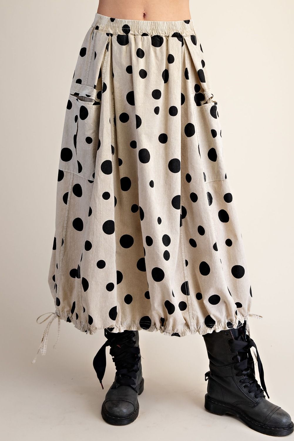 Polka dot skirt with black boots on a plain background