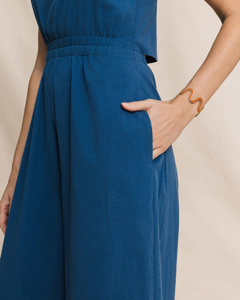 Blue dress worn by a person with a beige background