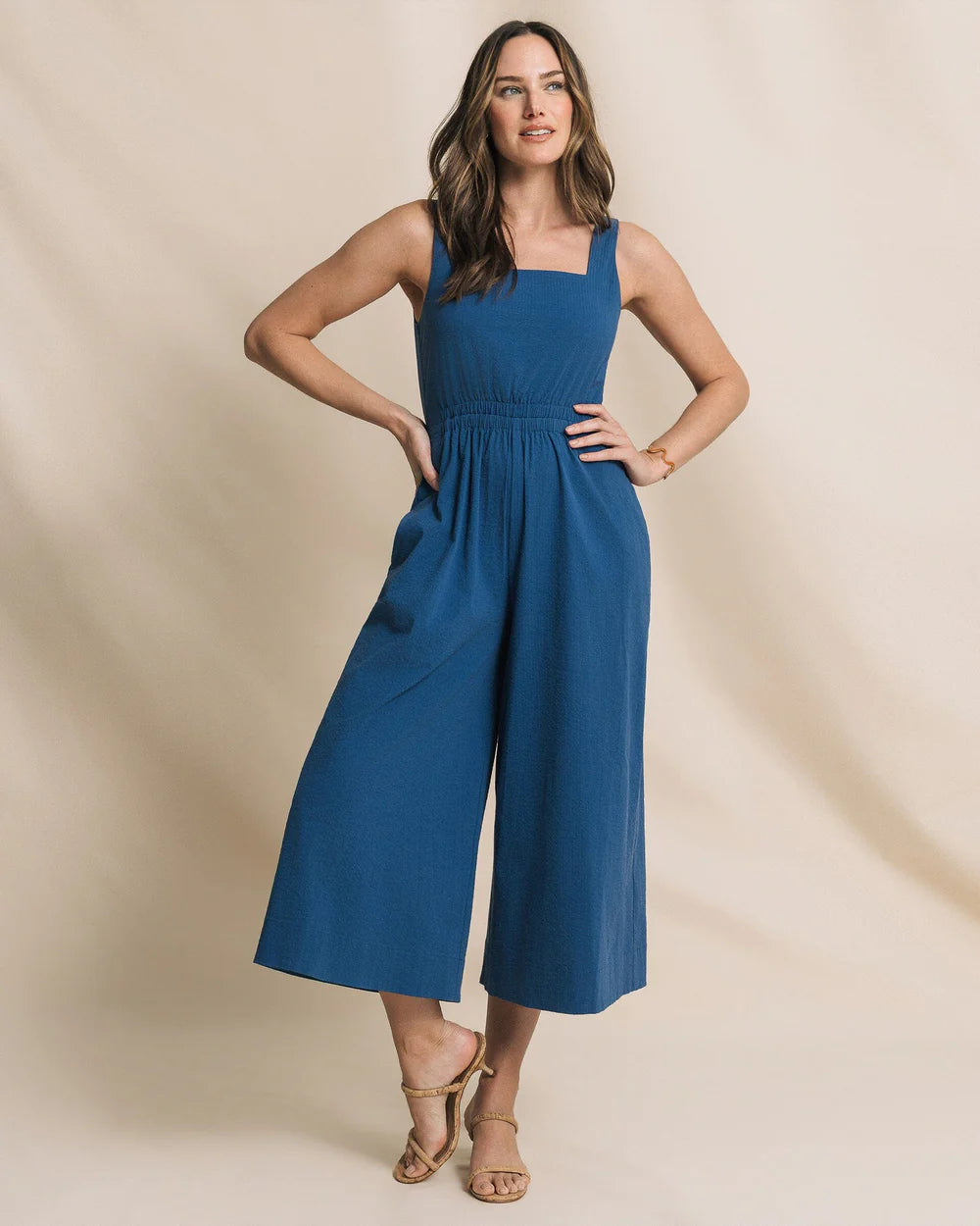Woman wearing a blue dress against a beige background