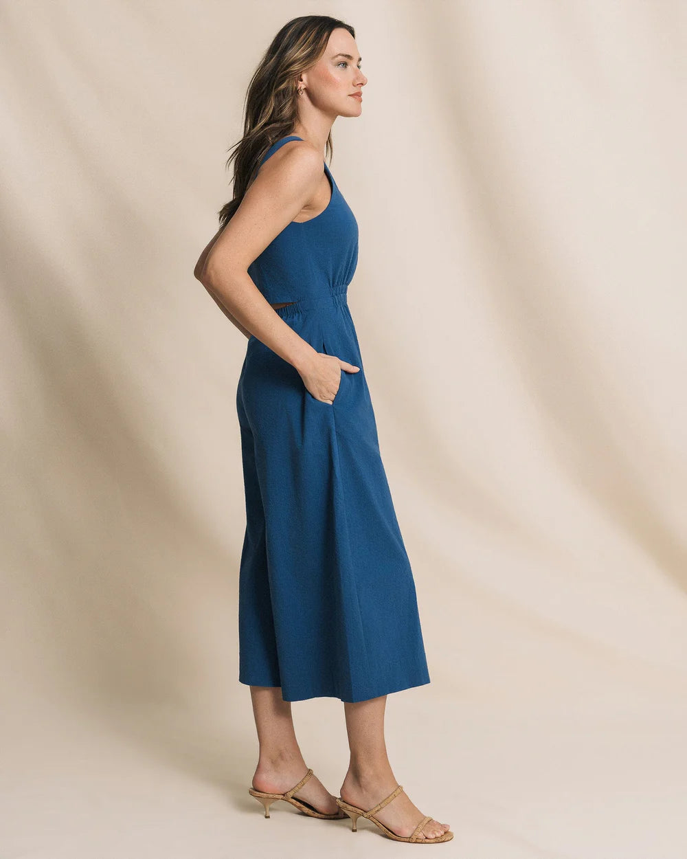 Woman wearing a blue dress against a beige background