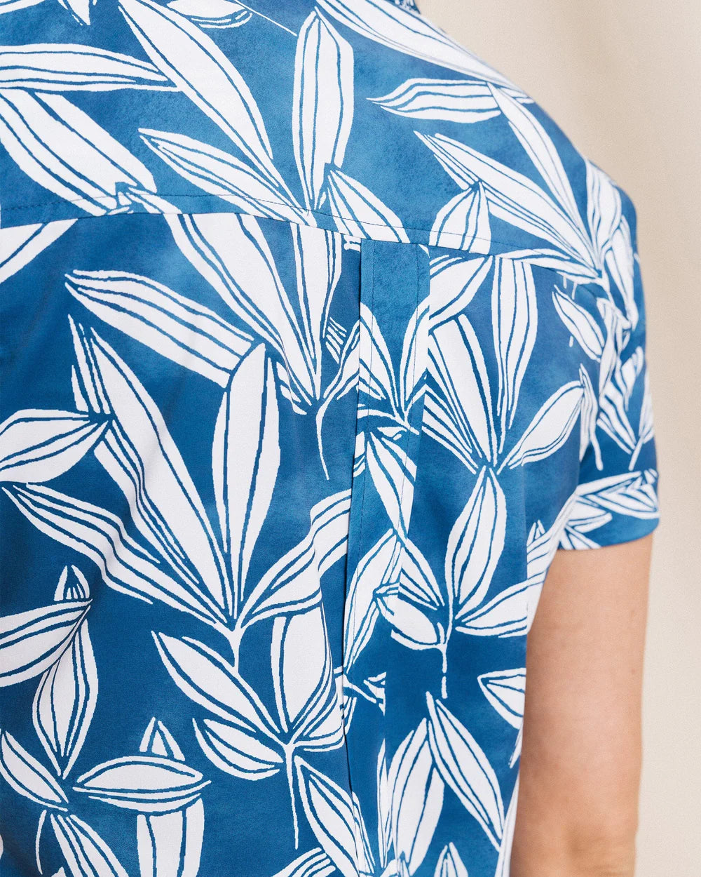 Blue shirt with white leaf pattern on a beige background