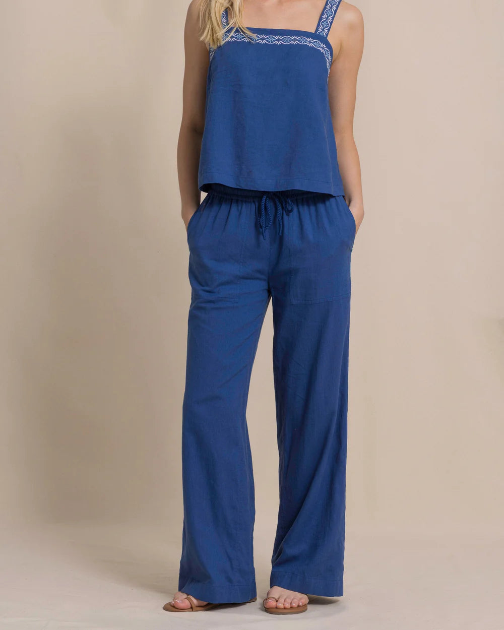 Woman wearing a blue jumpsuit on a beige background