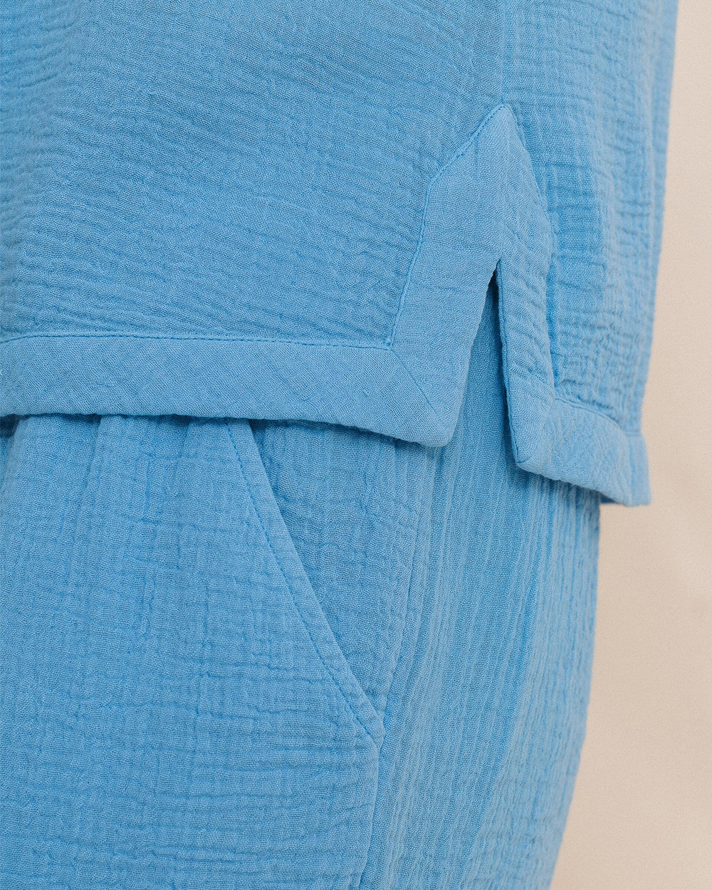 Close-up of a textured blue garment with a beige background
