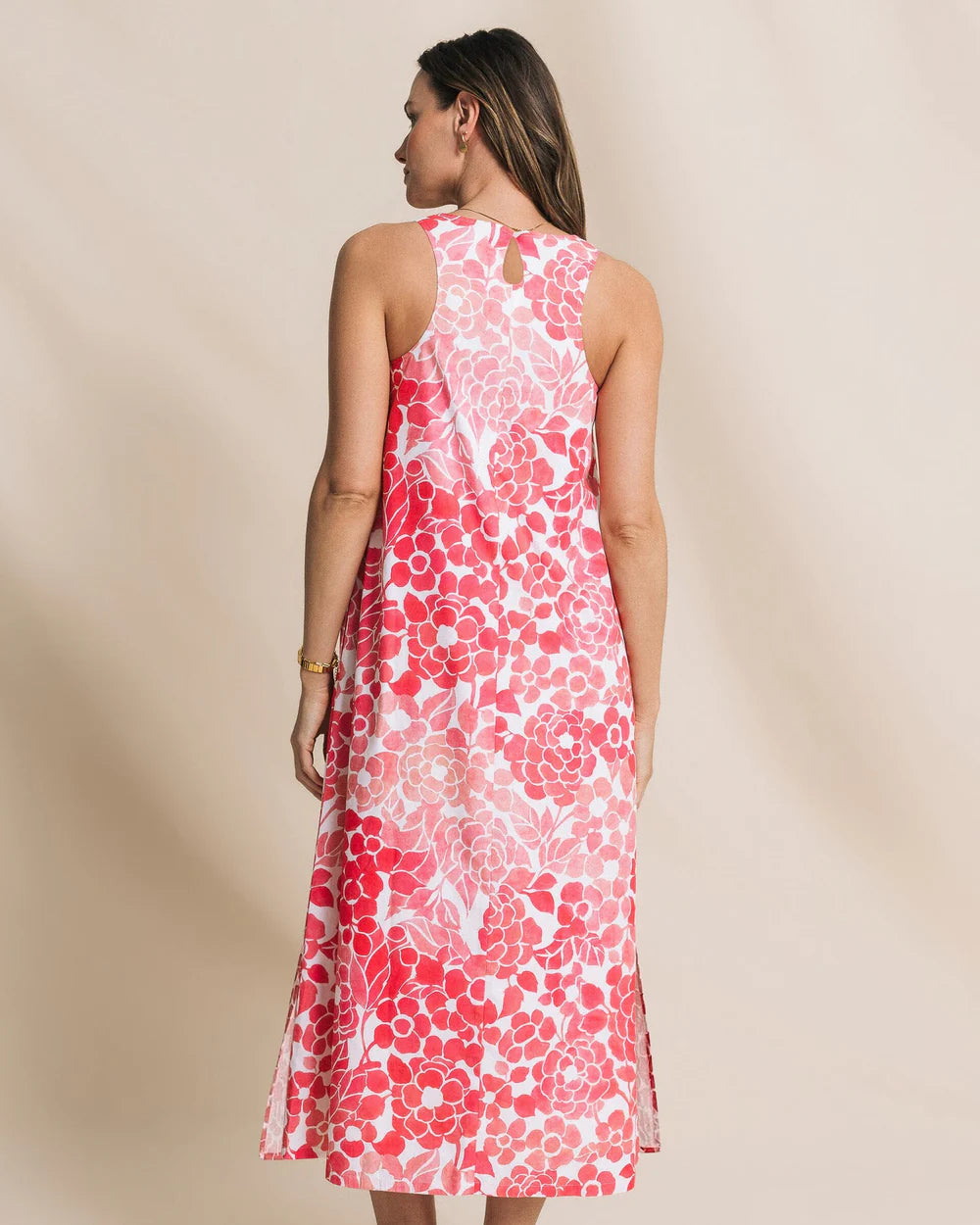 Woman wearing a pink floral dress against a beige background