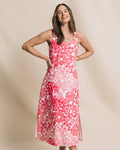 Woman wearing a pink floral dress against a beige background