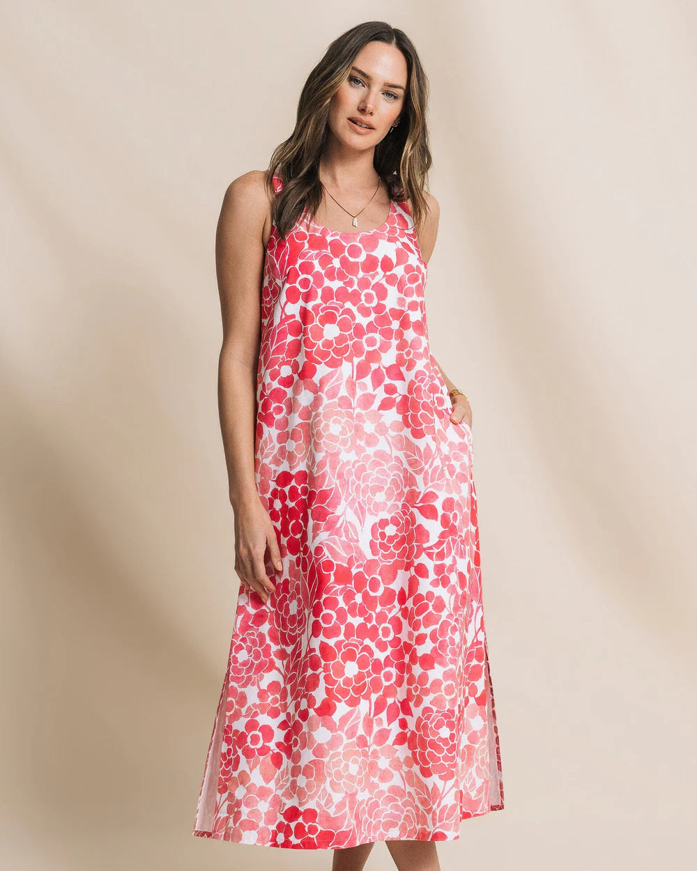 Woman wearing a red floral dress against a beige background