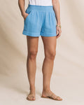 Person wearing light blue shorts on a beige background