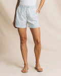 Person wearing light blue patterned shorts on a beige background